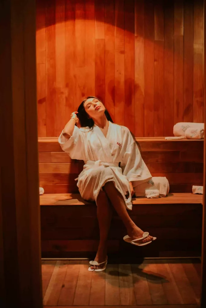 Eine Frau entspannt im bademantel in einer Sauna